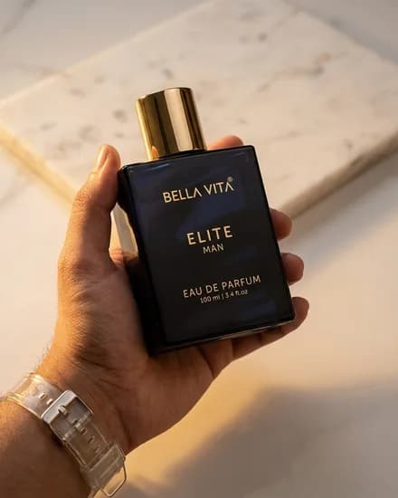The bottle held at the wrist beside pale marble